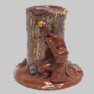 30-20247, Rare PA redware figural penny bank, indian behind tree stump, yellow and blue slip. $8,500